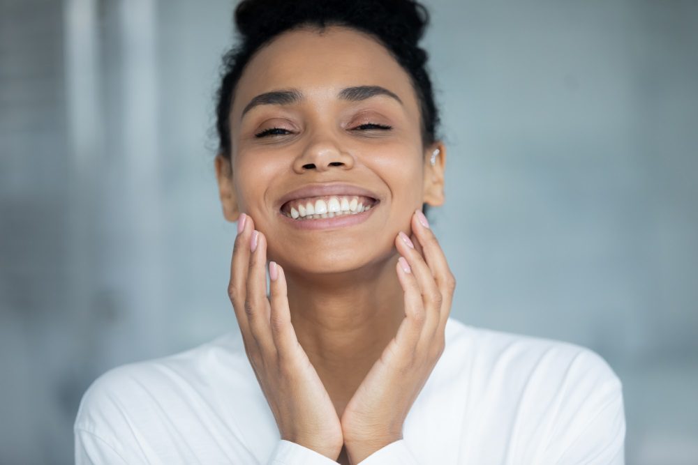 Beautiful woman touching her face and enjoying the results of Botox.